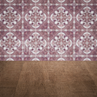 Wood table top and blur vintage ceramic tile pattern wall