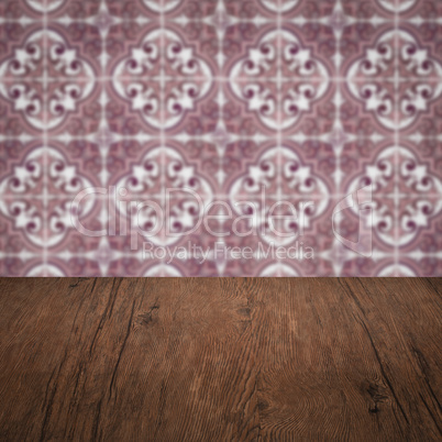 Wood table top and blur vintage ceramic tile pattern wall