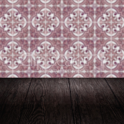 Wood table top and blur vintage ceramic tile pattern wall