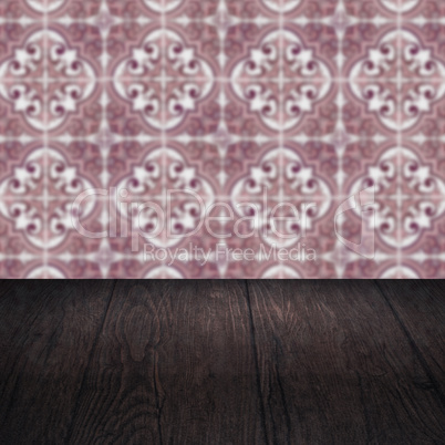 Wood table top and blur vintage ceramic tile pattern wall