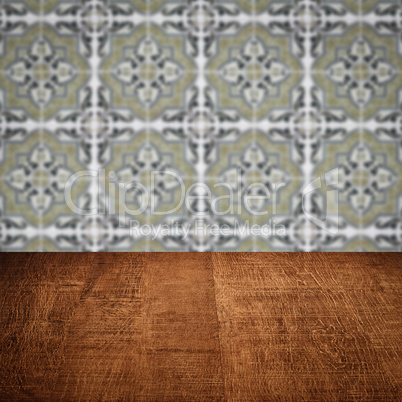 Wood table top and blur vintage ceramic tile pattern wall