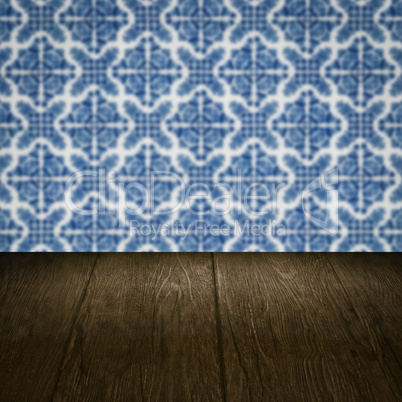 Wood table top and blur vintage ceramic tile pattern wall Wood table top and blur vintage ceramic tile pattern wall
