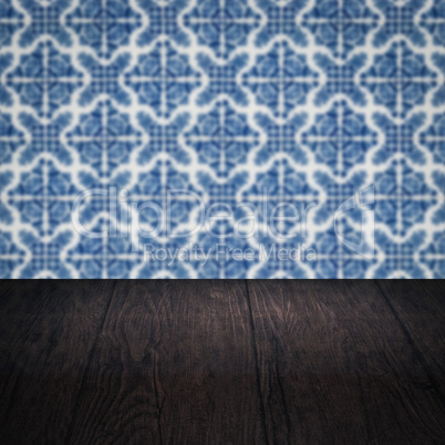 Wood table top and blur vintage ceramic tile pattern wall