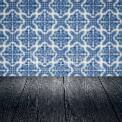 Wood table top and blur vintage ceramic tile pattern wall Wood table top and blur vintage ceramic tile pattern wall