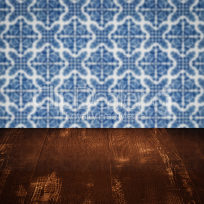 Wood table top and blur vintage ceramic tile pattern wall