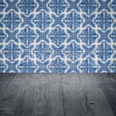 Wood table top and blur vintage ceramic tile pattern wall