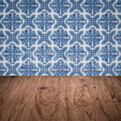 Wood table top and blur vintage ceramic tile pattern wall