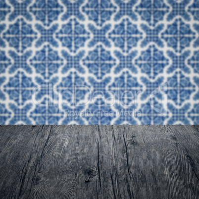 Wood table top and blur vintage ceramic tile pattern wall