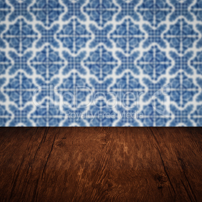 Wood table top and blur vintage ceramic tile pattern wall