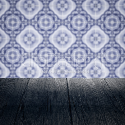 Wood table top and blur vintage ceramic tile pattern wall