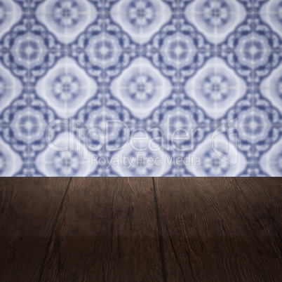 Wood table top and blur vintage ceramic tile pattern wall Wood table top and blur vintage ceramic tile pattern wall