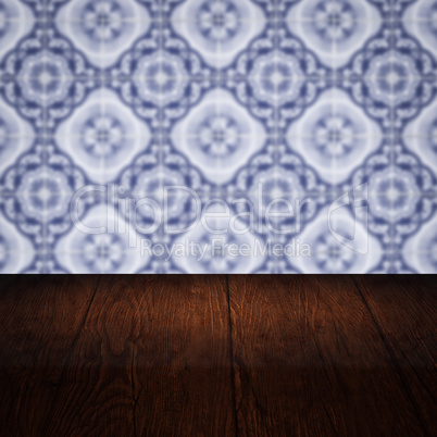 Wood table top and blur vintage ceramic tile pattern wall