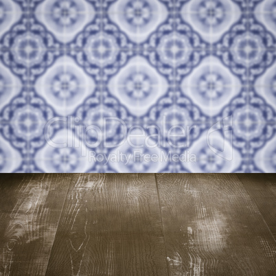 Wood table top and blur vintage ceramic tile pattern wall