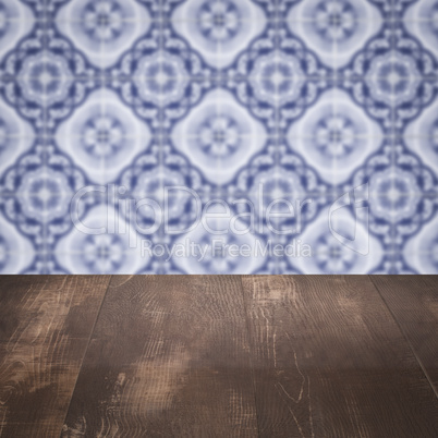 Wood table top and blur vintage ceramic tile pattern wall