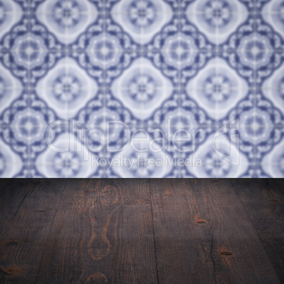 Wood table top and blur vintage ceramic tile pattern wall