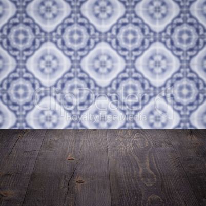 Wood table top and blur vintage ceramic tile pattern wall