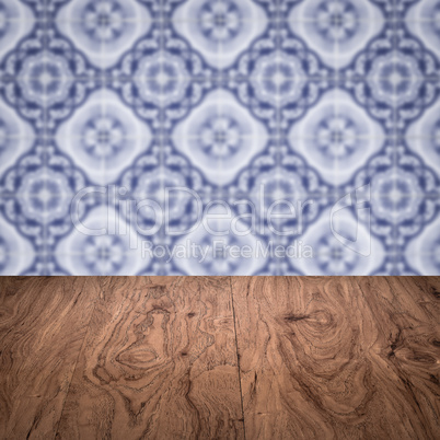 Wood table top and blur vintage ceramic tile pattern wall