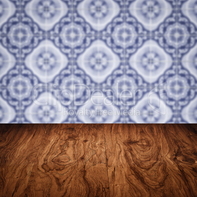 Wood table top and blur vintage ceramic tile pattern wall