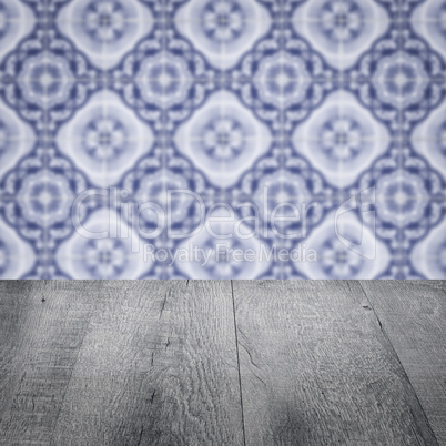 Wood table top and blur vintage ceramic tile pattern wall