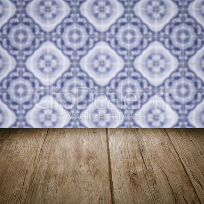 Wood table top and blur vintage ceramic tile pattern wall