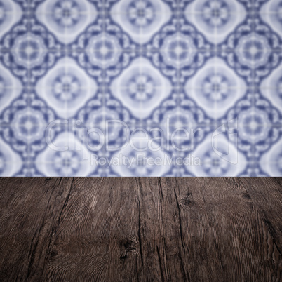 Wood table top and blur vintage ceramic tile pattern wall