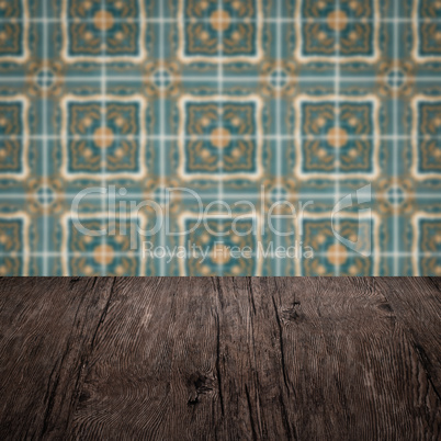 Wood table top and blur vintage ceramic tile pattern wall