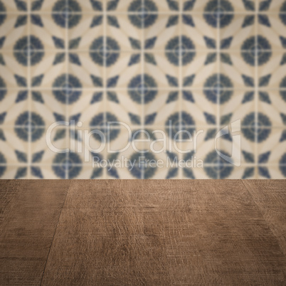 Wood table top and blur vintage ceramic tile pattern wall