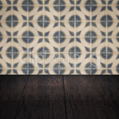 Wood table top and blur vintage ceramic tile pattern wall