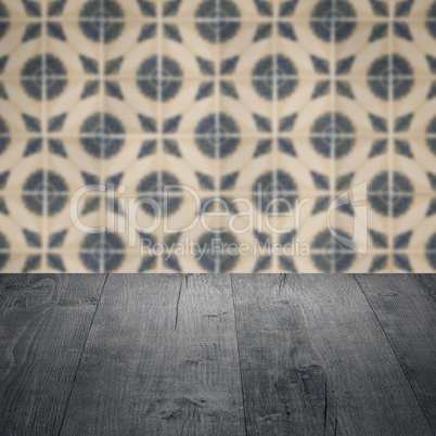 Wood table top and blur vintage ceramic tile pattern wall