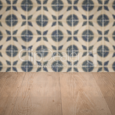 Wood table top and blur vintage ceramic tile pattern wall