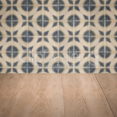 Wood table top and blur vintage ceramic tile pattern wall Wood table top and blur vintage ceramic tile pattern wall