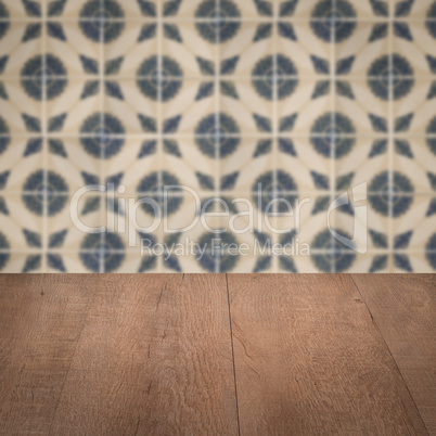 Wood table top and blur vintage ceramic tile pattern wall