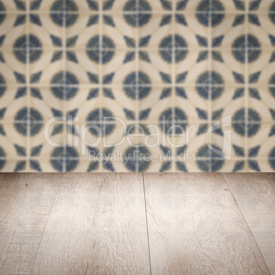 Wood table top and blur vintage ceramic tile pattern wall