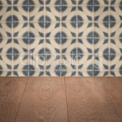 Wood table top and blur vintage ceramic tile pattern wall