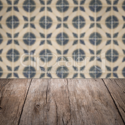 Wood table top and blur vintage ceramic tile pattern wall