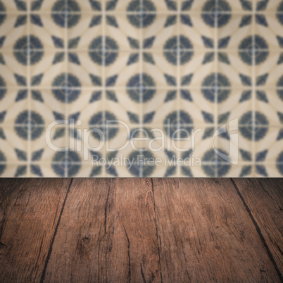 Wood table top and blur vintage ceramic tile pattern wall