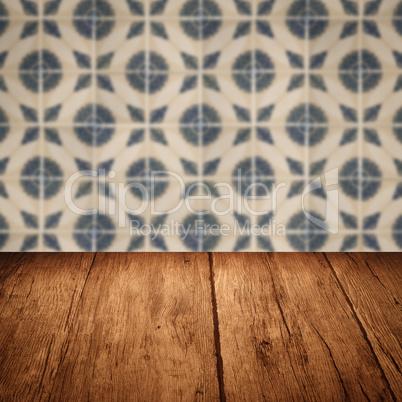 Wood table top and blur vintage ceramic tile pattern wall