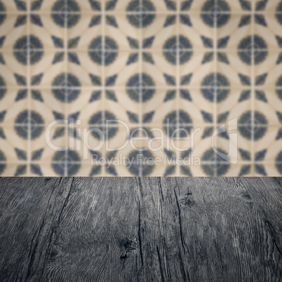 Wood table top and blur vintage ceramic tile pattern wall