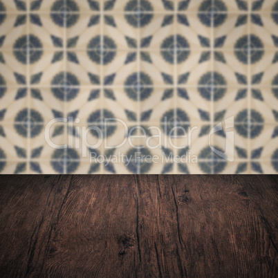 Wood table top and blur vintage ceramic tile pattern wall