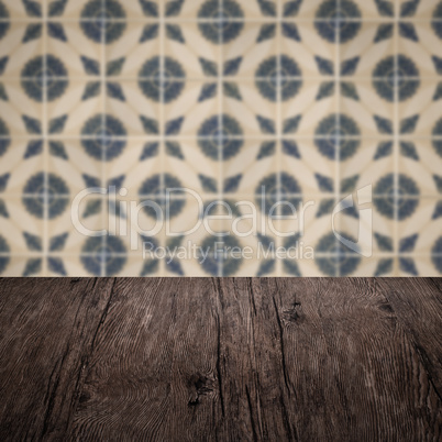 Wood table top and blur vintage ceramic tile pattern wall Wood table top and blur vintage ceramic tile pattern wall