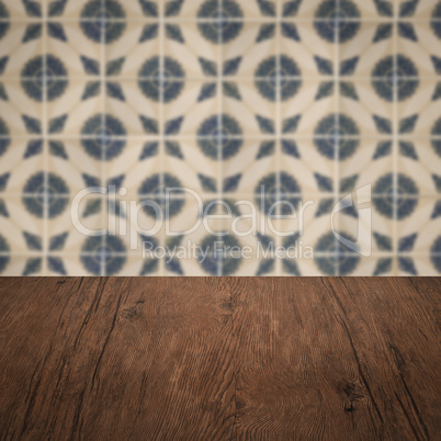 Wood table top and blur vintage ceramic tile pattern wall