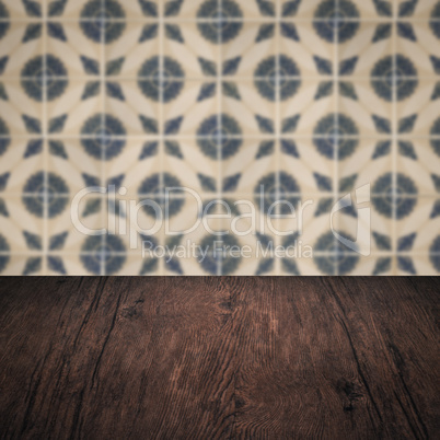 Wood table top and blur vintage ceramic tile pattern wall Wood table top and blur vintage ceramic tile pattern wall