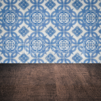 Wood table top and blur vintage ceramic tile pattern wall