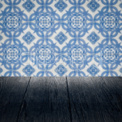 Wood table top and blur vintage ceramic tile pattern wall