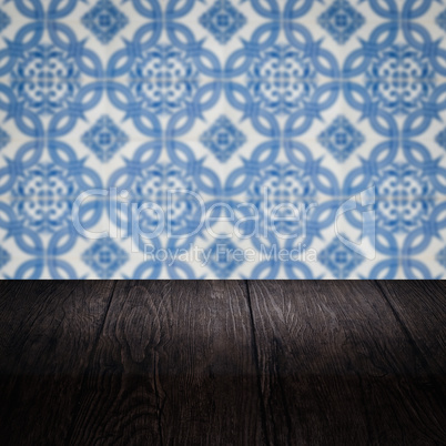 Wood table top and blur vintage ceramic tile pattern wall