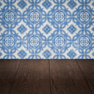 Wood table top and blur vintage ceramic tile pattern wall