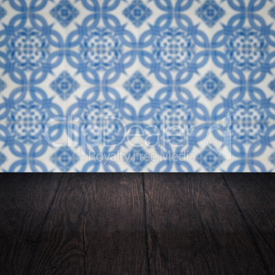 Wood table top and blur vintage ceramic tile pattern wall