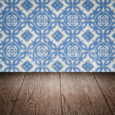 Wood table top and blur vintage ceramic tile pattern wall Wood table top and blur vintage ceramic tile pattern wall