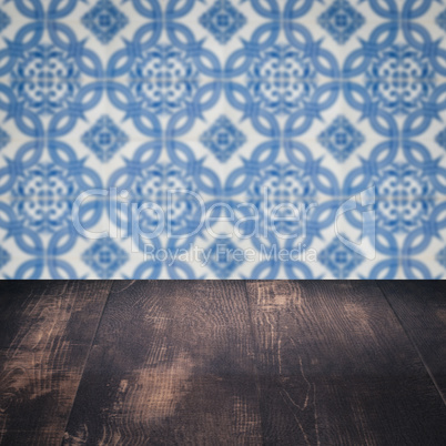 Wood table top and blur vintage ceramic tile pattern wall Wood table top and blur vintage ceramic tile pattern wall