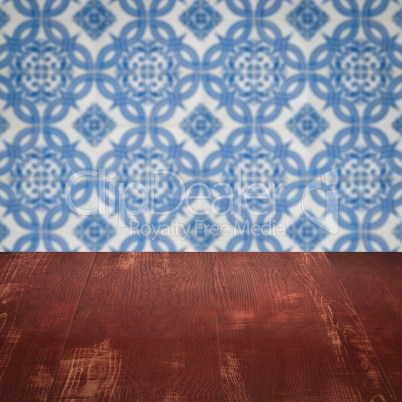 Wood table top and blur vintage ceramic tile pattern wall